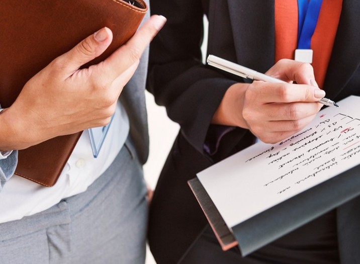Image de deux collègues observant des documents corporate btob