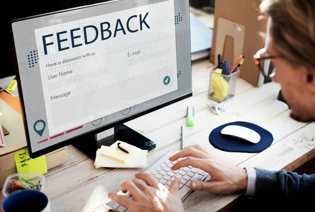 Homme devant un ordinateur avec feedback d'enquêtes
